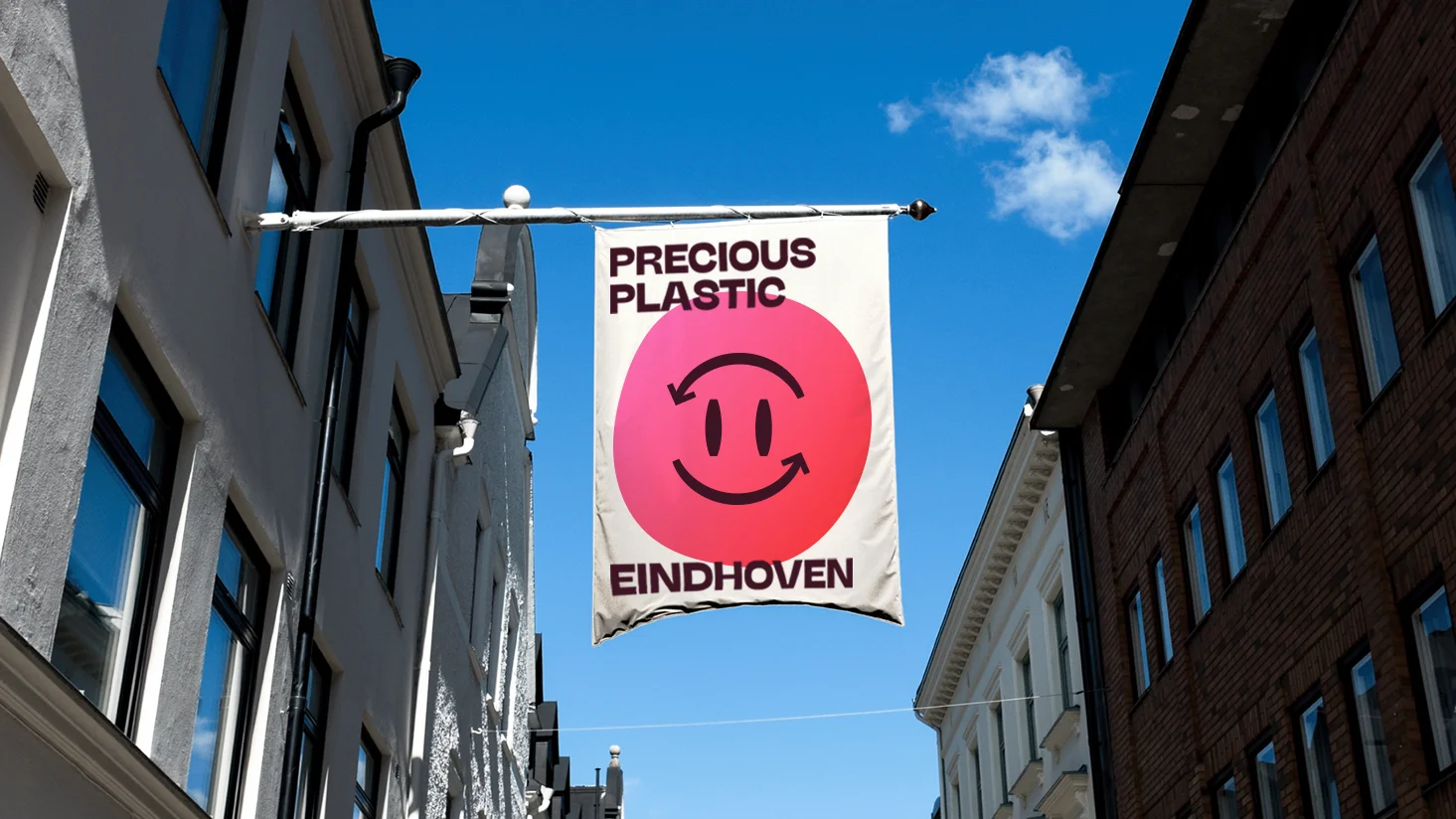 precious plastic's logo on a flag in the street